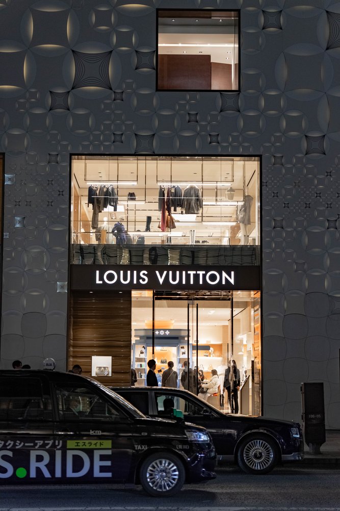 Louis Vuitton store frontage at night in Ginza with Tokyo taxis parked outside — Zen Den Studios